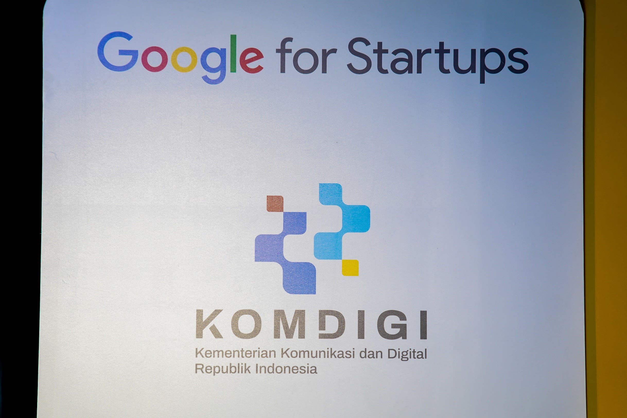 Backdrop kemitraan Google for Startups dan Komdigi (Kementerian Komunikasi dan Digital Republik Indonesia) di AI Showcase Day