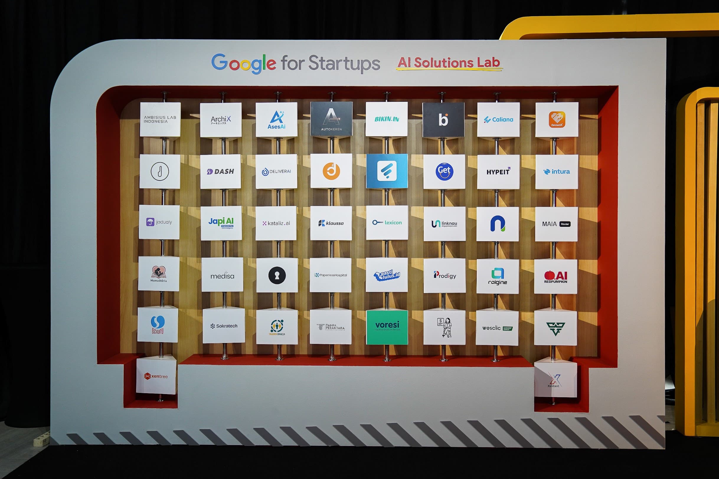 Dinding startup Google for Startups AI Solutions Lab yang menampilkan Intura dan puluhan startup AI Indonesia